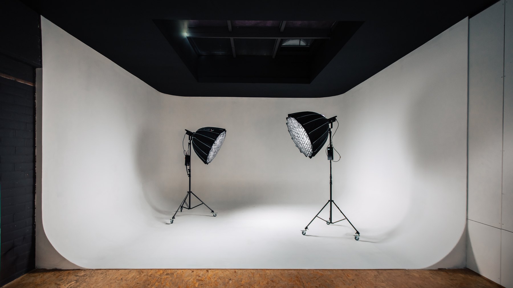 De witte cyclorama van Studio Dwars met twee softboxen op statief
